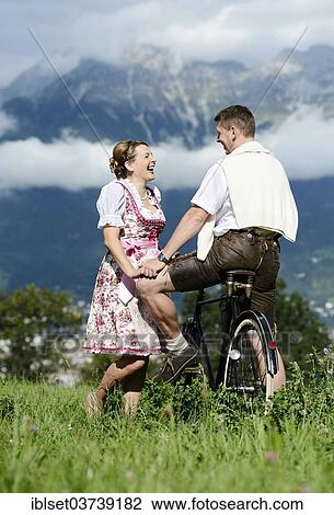 "Man and a woman wearing traditional costume with an old bicycle within a natural landscape, Aldrans, Tyrol, Austria, Europe" View Large Photo Image Stock Image - "Man and a woman wearing traditional costume with an old bicycle within a natural landscape, Aldrans, Tyrol, Austria, Europe". Fotosearch