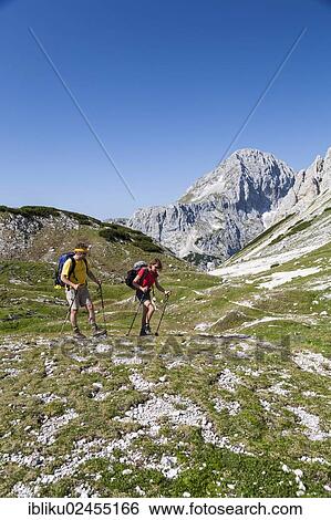 "Man and a woman while hiking, climbing from the Vodnikov dom refuge to Triglav Mountain, Triglav National Park, Slovenia, Europe" View Large Photo Image Stock Photograph - "Man and a woman while hiking, climbing from the Vodnikov dom refuge to Triglav Mountain, Triglav National Park, Slovenia, Europe". Fotosearch