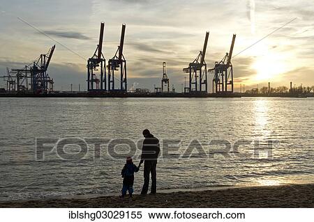 "Man and child standing on the shore in front of gantry cranes, Container Terminal Burchardkai, Hamburg-Port, Hamburg, Hamburg, Germany, Europe" View Large Photo Image Stock Photography - "Man and child standing on the shore in front of gantry cranes, Container Terminal Burchardkai, Hamburg-Port, Hamburg, Hamburg, Germany, Europe". Fotosearch
