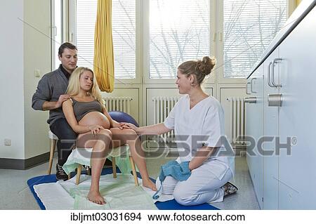Picture - "Man and woman in the delivery room during childbirth, the woman is leaning exhausted against her husband during a pause between contractions, Germany, Europe". Fotosearch