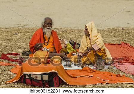 Stock Image - "Man and woman sittingat the Sangam, the confluence of the rivers Ganges, Yamuna and Saraswati, during Kumbha Mela, Allahabad, Uttar Pradesh, India, Asia". Fotosearch