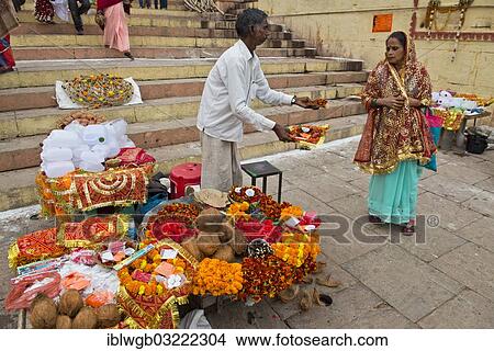 "Man at a stall offering small bowls with flowers and ritual offerings to a passing woman, the sacrificial bowls are offered in honour of the Mother Goddess Ganga on the banks of the Ganges River, Varanasi, Uttar Pradesh, India, Asia" View Large Photo Image Picture - "Man at a stall offering small bowls with flowers and ritual offerings to a passing woman, the sacrificial bowls are offered in honour of the Mother Goddess Ganga on the banks of the Ganges River, Varanasi, Uttar Pradesh, India, Asia". Fotosearch