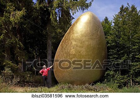 "Man beside the sculpture """"What came first? """" along the Waldskulpturenweg forest sculpture trail in Wittgenstein-Sauerland, Kuhhude, Bad Berleburg, North Rhine-Westphalia, Germany, Europe" View Large Photo Image Stock Photograph - "Man beside the sculpture """"What came first? """" along the Waldskulpturenweg forest sculpture trail in Wittgenstein-Sauerland, Kuhhude, Bad Berleburg, North Rhine-Westphalia, Germany, Europe". Fotosearch