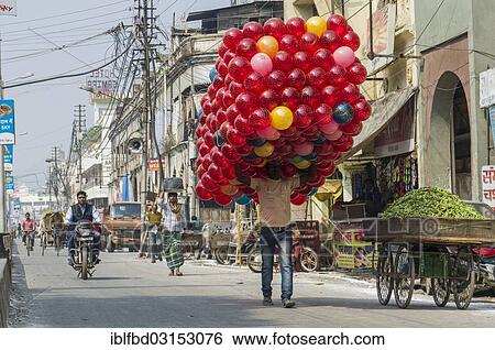 "Man carrying a huge pack of red toy balls along a street, Allahabad, Uttar Pradesh, India, Asia" View Large Photo Image Stock Photograph - "Man carrying a huge pack of red toy balls along a street, Allahabad, Uttar Pradesh, India, Asia". Fotosearch