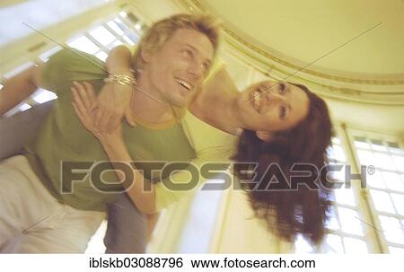 Man carrying a woman piggyback View Large Photo Image Stock Photograph - Man carrying a woman piggyback. Fotosearch