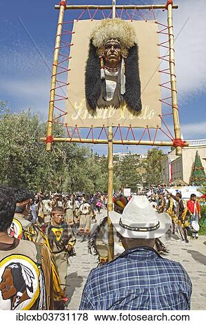 Stock Photo - "Man carrying an American Indian head on the sign of a dance group, Andacollo, Coquimbo Region, Chile, South America". Fotosearch