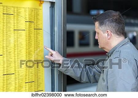 "Man checking the timetable for a train departure, Duesseldorf, North Rhine-Westphalia, Germany, Europe" View Large Photo Image Stock Image - "Man checking the timetable for a train departure, Duesseldorf, North Rhine-Westphalia, Germany, Europe". Fotosearch