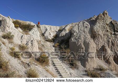 Man climbing a ladder in the Badlands, Badlands National Park, South Dakota, USA View Large Photo Image Picture - Man climbing a ladder in the Badlands, Badlands National Park, South Dakota, USA. Fotosearch