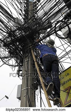 "Man climbing up a ladder to fix power lines, pylon, Chiang Mai, Thailand, Asia" View Large Photo Image Stock Image - "Man climbing up a ladder to fix power lines, pylon, Chiang Mai, Thailand, Asia". Fotosearch
