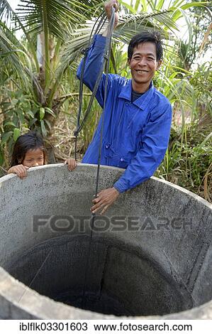 "Man fetching water from a well, Trapang Village, Bathi District, Takeo Province, Cambodia, Asia" View Large Photo Image Stock Image - "Man fetching water from a well, Trapang Village, Bathi District, Takeo Province, Cambodia, Asia". Fotosearch
