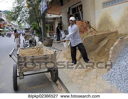 Stock Photo - "Man filling cart with sand, Phnom Penh, Cambodia, Asia". Fotosearch
