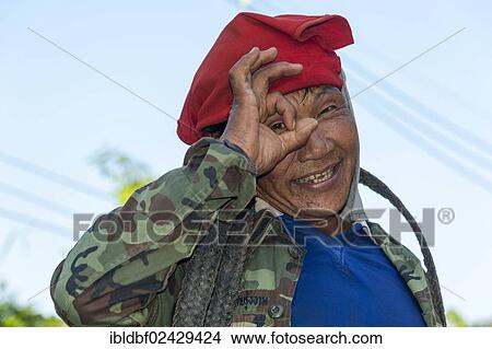 Picture - "Man from the Shan or Thai Yai ethnic minority imitating a camera by holding his fingers in front of his face, portrait, Soppong or Pang Mapha area, Northern Thailand, Thailand, Asia". Fotosearch