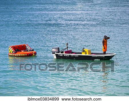Stock Photo - "Man hiring out boats waits for customers, Rodney Bay, Saint Lucia, Windward Islands, Lesser Antilles, North America". Fotosearch