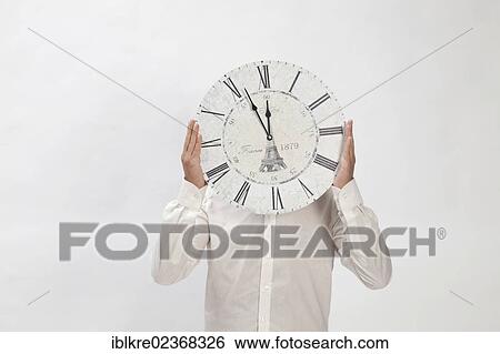 "Man holding a clock at eleven fifty-five, almost high noon" View Large Photo Image Stock Photograph - "Man holding a clock at eleven fifty-five, almost high noon". Fotosearch