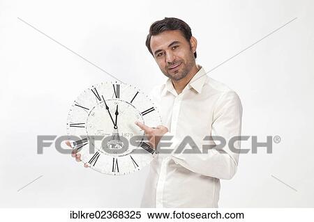 "Man holding a clock at eleven fifty-five, almost high noon" View Large Photo Image Stock Photography - "Man holding a clock at eleven fifty-five, almost high noon". Fotosearch