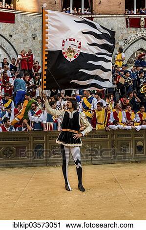 Stock Image - "Man holding a flag, historical parade before the Palio di Siena horse race, Siena, Tuscany, Italy, Europe". Fotosearch