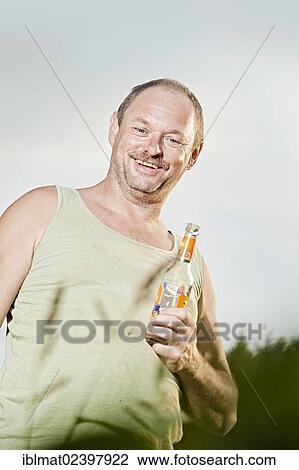 Stock Image - Man holding a soft drink bottle. Fotosearch