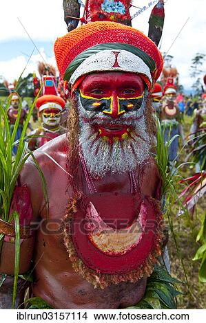 Picture - "Man in a colourfully decorated costume with face paint at the traditional sing-sing gathering, Hochland, Mount Hagen, Western Highlands Province, Papua New Guinea, Oceania". Fotosearch