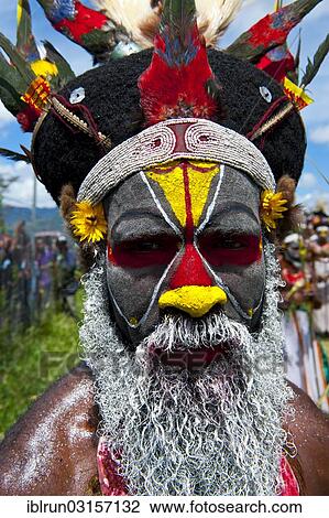 Stock Image - "Man in a colourfully decorated costume with face paint at the traditional sing-sing gathering, Hochland, Mount Hagen, Western Highlands Province, Papua New Guinea, Oceania". Fotosearch