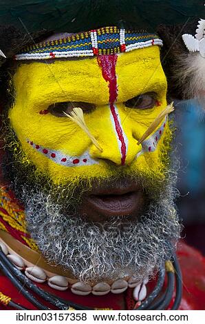 Stock Photo - "Man in a colourfully decorated costume with face paint is celebrating at the traditional Sing Sing gathering in the highlands, Paya, Papua New Guinea, Oceania". Fotosearch