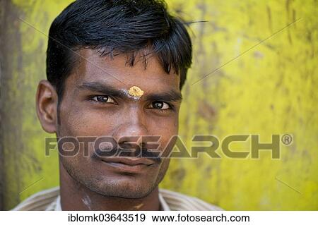 "Man in front of lemon-yellow wall with bindi on his forehead, portrait, Meenakshi Amman Temple or Sri Meenakshi Sundareswarar Temple, Madurai, Tamil Nadu, India, Asia" View Large Photo Image Stock Photo - "Man in front of lemon-yellow wall with bindi on his forehead, portrait, Meenakshi Amman Temple or Sri Meenakshi Sundareswarar Temple, Madurai, Tamil Nadu, India, Asia". Fotosearch