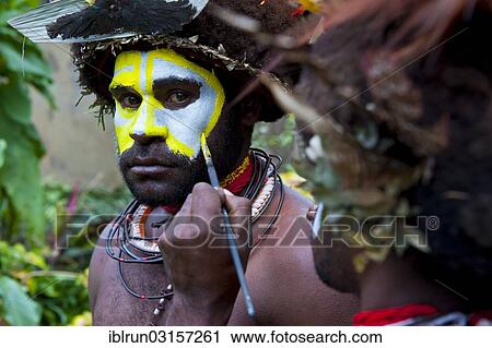 Stock Image - "Man is made up for the traditional Sing Sing gathering in the highlands, Paya, Papua New Guinea, Oceania". Fotosearch