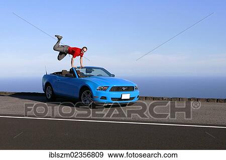 "Man jumping with joy on a sky-blue Ford Mustang convertible by the sea, Big Island, Hawaii, USA" View Large Photo Image Stock Photo - "Man jumping with joy on a sky-blue Ford Mustang convertible by the sea, Big Island, Hawaii, USA". Fotosearch