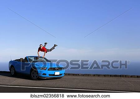 "Man jumping with joy on a sky-blue Ford Mustang convertible by the sea, Big Island, Hawaii, USA" View Large Photo Image Stock Photo - "Man jumping with joy on a sky-blue Ford Mustang convertible by the sea, Big Island, Hawaii, USA". Fotosearch