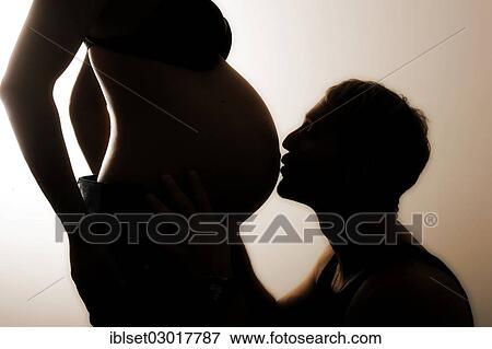 "Man kissing the pregnant belly of his wife, silhouette" View Large Photo Image Stock Photo - "Man kissing the pregnant belly of his wife, silhouette". Fotosearch