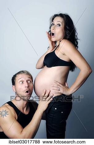 "Man listening to the pregnant belly of his wife, both with an astonished expression" View Large Photo Image Stock Photo - "Man listening to the pregnant belly of his wife, both with an astonished expression". Fotosearch
