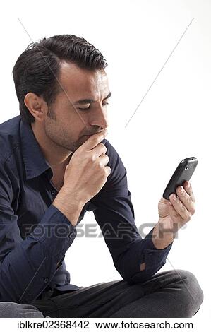 Man looking at a mobile phone View Large Photo Image Stock Image - Man looking at a mobile phone. Fotosearch