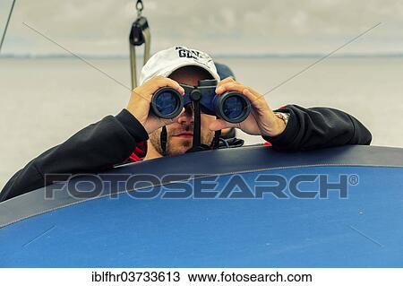"Man looking through binoculars, Baltic Sea, Mecklenburg-Western Pomerania, Germany, Europe" View Large Photo Image Stock Image - "Man looking through binoculars, Baltic Sea, Mecklenburg-Western Pomerania, Germany, Europe". Fotosearch
