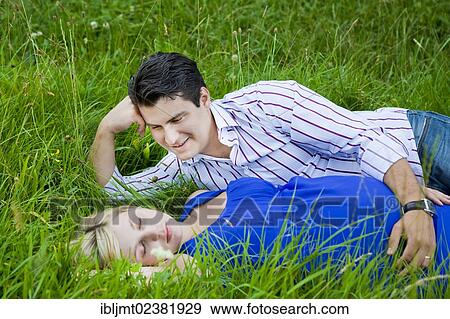 Man lying with his pregnant woman in the grass and looking at her tenderly View Large Photo Image Stock Photo - Man lying with his pregnant woman in the grass and looking at her tenderly. Fotosearch