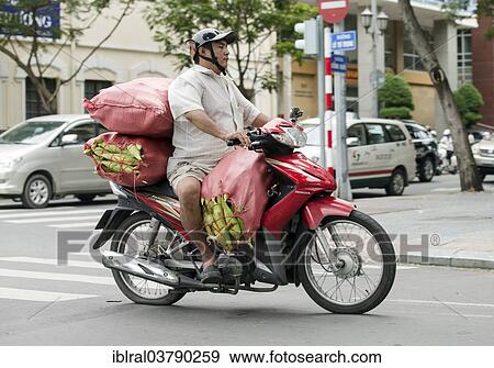 Stock Photo - "Man on a packed bike, Ho Chi Minh City, Vietnam, Asia". Fotosearch