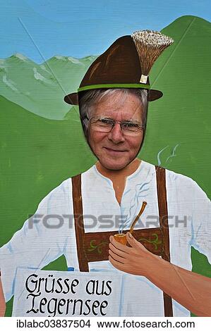 Picture - "Man putting his head through a poster wall with a picture of a man in traditional costume, Tegernsee, Bavaria, Germany, Europe". Fotosearch