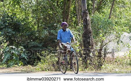 Stock Image - "Man riding a bicycle, Tamil Nadu, India, Asia". Fotosearch