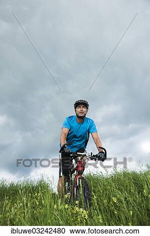 "Man riding a mountain bike across a meadow, Mannheim, Baden-Wurttemberg, Germany, Europe" View Large Photo Image Stock Image - "Man riding a mountain bike across a meadow, Mannheim, Baden-Wurttemberg, Germany, Europe". Fotosearch
