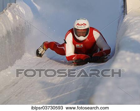 Stock Image - "Man riding a skeleton sled at the Innsbruck bobsleigh track, Igls Olympic Bobsled Run, Igls, Innsbruck, Tyrol, Austria, Europe". Fotosearch