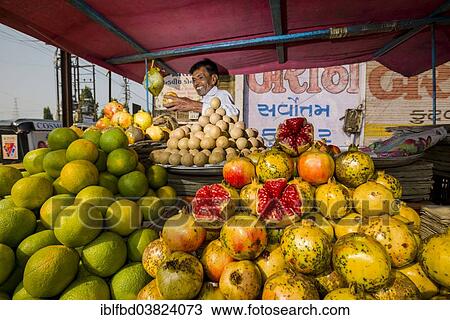 Stock Image - "Man selling friut at a market, Bhavnagar, Gujarat, India, Asia". Fotosearch