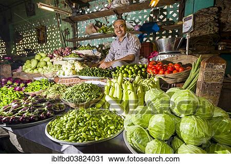 Stock Image - "Man selling vegetables at a vegetable market, Bhavnagar, Gujarat, India, Asia". Fotosearch