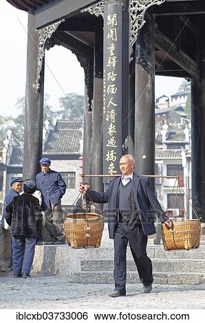"Man shouldering bamboo baskets in front of the Kuixingge Pagoda, historic center, Zhenyuan, Guizhou, China, People's Republic of China, Asia" View Large Photo Image Stock Photograph - "Man shouldering bamboo baskets in front of the Kuixingge Pagoda, historic center, Zhenyuan, Guizhou, China, People's Republic of China, Asia". Fotosearch
