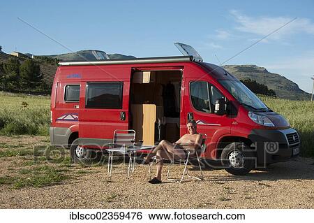 Stock Photograph - "Man sitting in front of a campervan, Segesta, Province Trapani, Sicily, Italy, Europe". Fotosearch