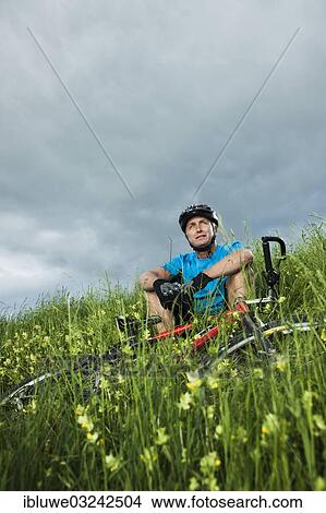 "Man sitting with a mountain bike in a meadow, Mannheim, Baden-Wurttemberg, Germany, Europe" View Large Photo Image Picture - "Man sitting with a mountain bike in a meadow, Mannheim, Baden-Wurttemberg, Germany, Europe". Fotosearch