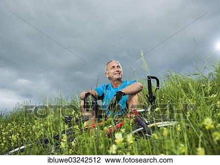"Man sitting with a mountain bike in a meadow, Mannheim, Baden-Wurttemberg, Germany, Europe" View Large Photo Image Stock Image - "Man sitting with a mountain bike in a meadow, Mannheim, Baden-Wurttemberg, Germany, Europe". Fotosearch