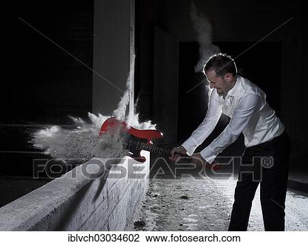 "Man smashing an electric guitar, Austria, Europe" View Large Photo Image Stock Image - "Man smashing an electric guitar, Austria, Europe". Fotosearch