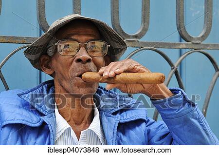 Stock Photo - "Man smoking a cigar, historic centre, Havana, Ciudad de La Habana, Cuba, North America". Fotosearch
