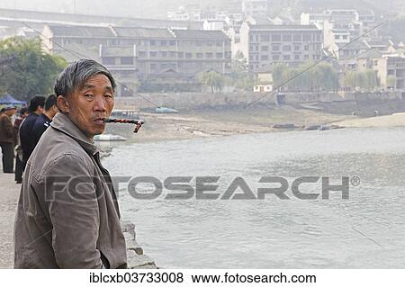"Man smoking a pipe on the Wuyang River, historic center, Zhenyuan, Guizhou, China, People's Republic of China, Asia" View Large Photo Image Stock Photo - "Man smoking a pipe on the Wuyang River, historic center, Zhenyuan, Guizhou, China, People's Republic of China, Asia". Fotosearch