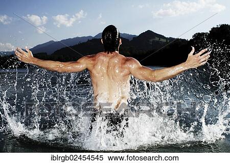 "Man splashing about in a lake in Sonthofen, Allgaeu, Bavaria, Germany, Europe" View Large Photo Image Stock Photography - "Man splashing about in a lake in Sonthofen, Allgaeu, Bavaria, Germany, Europe". Fotosearch