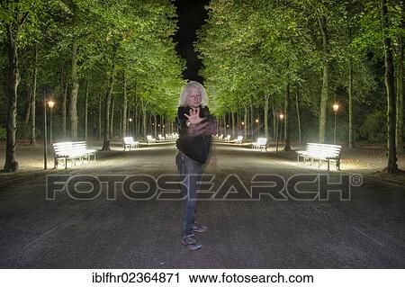 "Man standing in a defensive position in front of the rows of illiminated benches in the Hofgarten park, Duesseldorf, North Rhine-Westphalia, Germany, Europe" View Large Photo Image Stock Image - "Man standing in a defensive position in front of the rows of illiminated benches in the Hofgarten park, Duesseldorf, North Rhine-Westphalia, Germany, Europe". Fotosearch