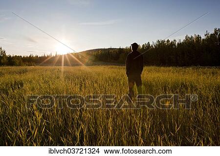 "Man standing in a field at sunset, Fairbanks, Alaska, USA" View Large Photo Image Picture - "Man standing in a field at sunset, Fairbanks, Alaska, USA". Fotosearch